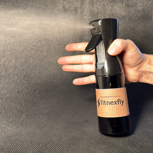 Detergente spray Fitnexfly in azione, progettato specificamente per la pulizia dei tappetini yoga e pilates, ideale per rimuovere sporco e batteri mantenendo materiali come sughero e gomma in perfette condizioni.